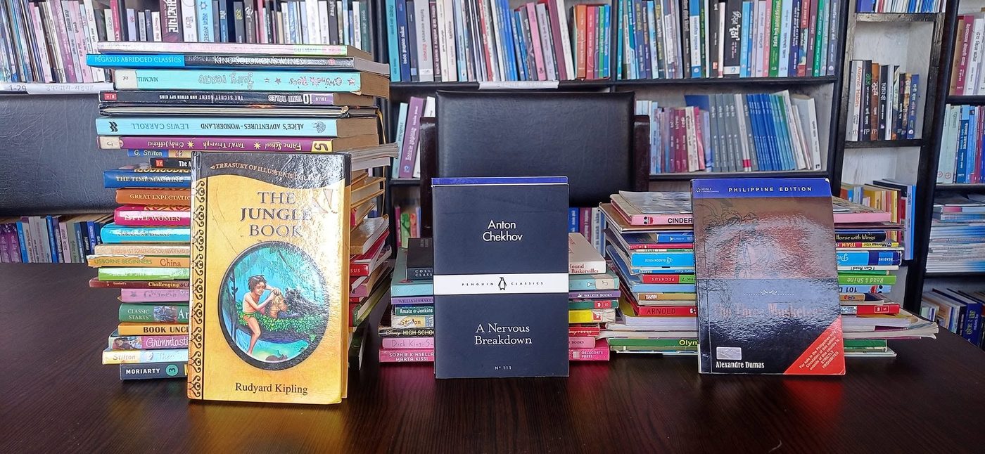 A selection of English and Nepali books from KMRDL's collection displayed on a table